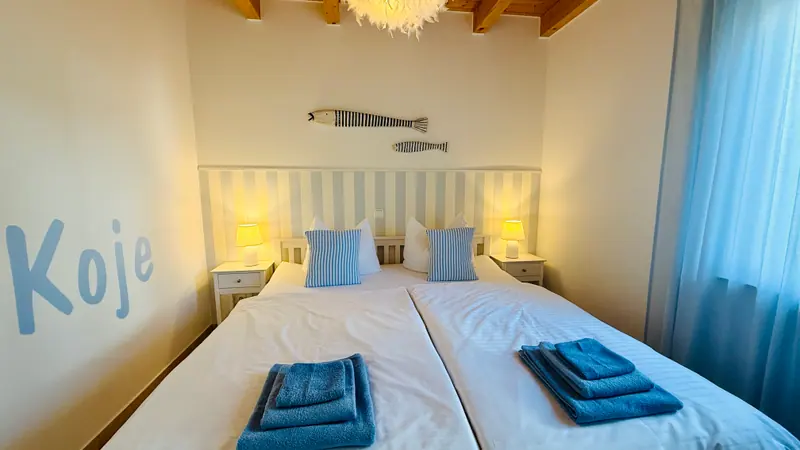 Schlafzimmer im Erdgeschoss mit Boxspringbett und gestreifter Wand