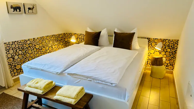 Schlafzimmer im Obergeschoss mit Doppelbett und Holzdekor