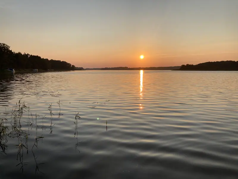 Sonnenuntergang über dem Plauer See mit goldener Lichtspur auf dem Wasser